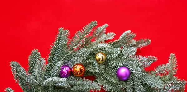 Top view of decorative christmas wreath with red and golden christmas toys  on red table. Christmas wreath with copy space. Winter holidays and Christmas celebration concept