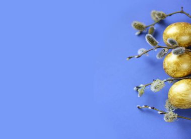 Paskalya arkaplanı, altın yumurtalar ve mavi arka planda söğüt ağacı. Poster, reklam, poster, kartpostal için şablon. Mutlu Paskalya arkaplanı üst görünümü, kopyalama alanı