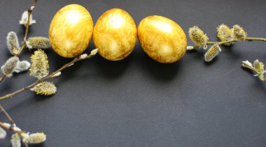 Paskalya arkaplanı, altın yumurtalar ve siyah arka planda söğüt ağacı. Poster, reklam, poster, kartpostal için şablon. Mutlu Paskalya arkaplanı üst görünümü, kopyalama alanı. Sancak boyutu