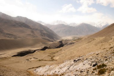Dağ yolu. Beyaz tepeler. Tehlikeli uçurumlar. Pamir. Hızlı nehir. Taşlar. Tehlikeli bir yol. Dünyanın çatısı. Talikistan. Badakhshan. Dağlarda seyahat. - Afganistan. Murgab..