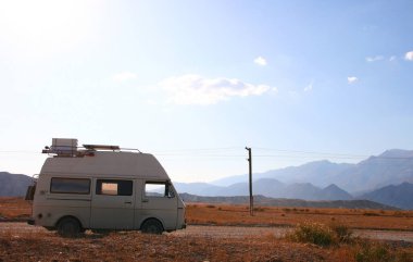 Kırgızistan - 10.09.2019: dağlarda araba. Kırgızistan 'daki dağ manzarası. Dağ vadisi manzarasında kayalar, çimenler ve taşlar. Dağ manzarası.