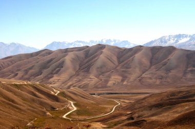 Kırgızistan 'daki güzel dağlar Kazarman yakınlarında. Güneşli bir günde Kırgızistan 'da dağları olan güzel bir manzara.