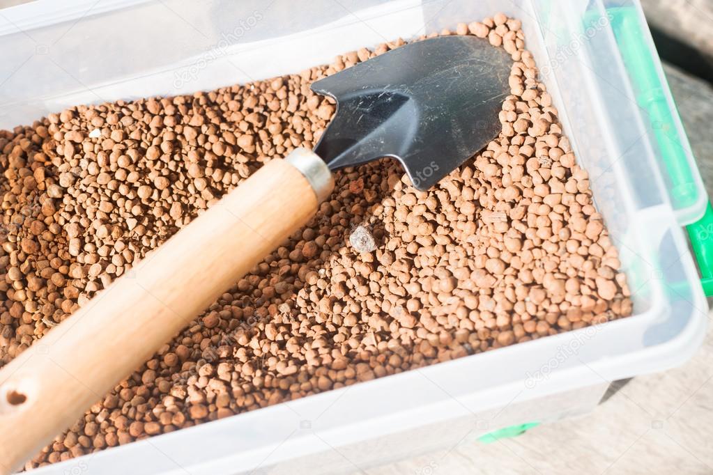pumice pebbles in bucket and gardening tool