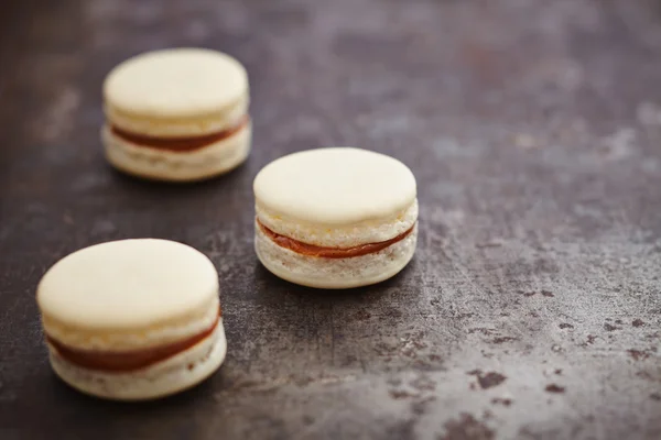 Três macarons com enchimento de caramelo — Fotografia de Stock