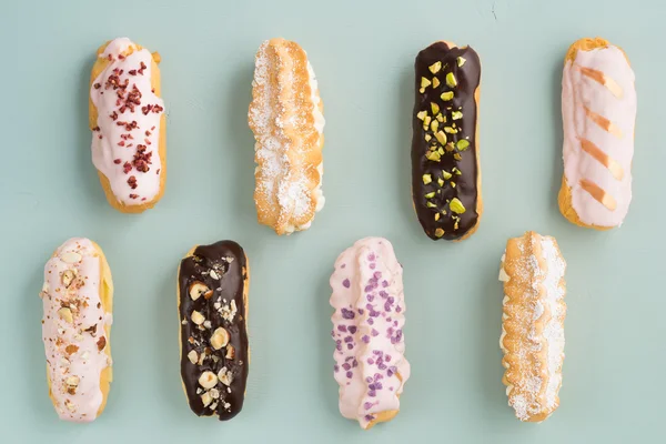 Eclairs with ganache and toppings — Stock Photo, Image