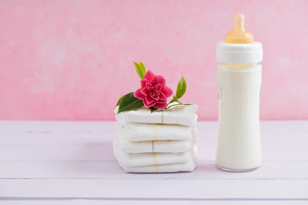 Baby milk bottle and diapers — Stock Photo, Image