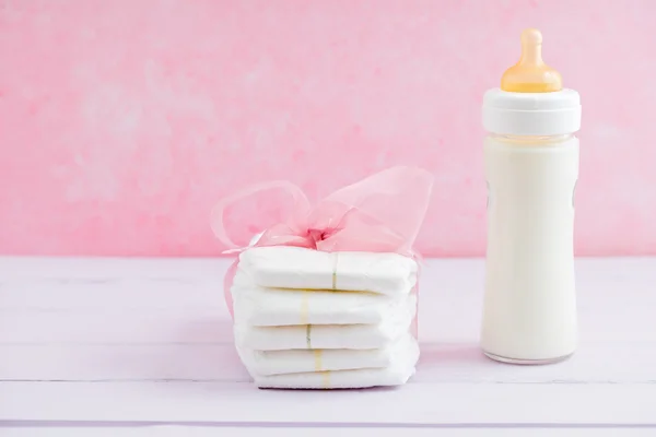 Baby milk bottle and diapers — Stock Photo, Image