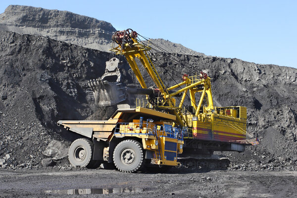 Coal mining. The dredge loads the truck coal.