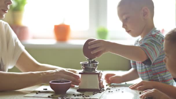 Twin brothers helping her mother to grind coffee — Stock Video