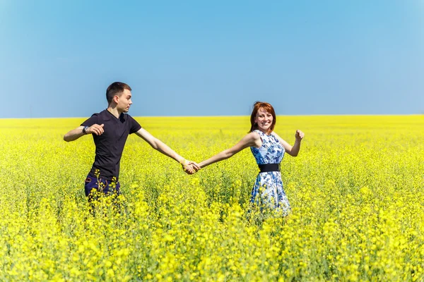 Bild eines glücklichen Paares beim Laufen auf der gelben Wiese — Stockfoto