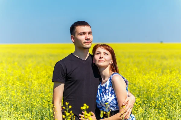Изображение счастливой пары, обнимающейся на желтом лугу — стоковое фото