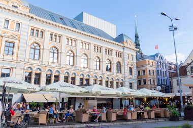 Riga üzerinde şehir merkezindeki kafede turistler ile görüntüleyin.