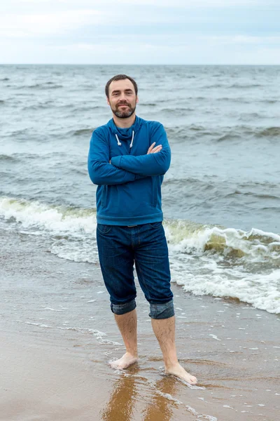 Un joven se para en la orilla del mar —  Fotos de Stock