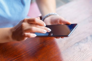 Genç bir kadın akıllı telefonunu kullanıyor