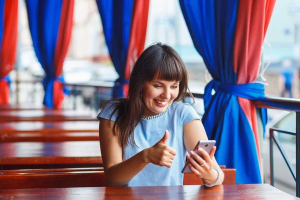 Donna mostra pollici in su nel telefono cellulare — Foto Stock