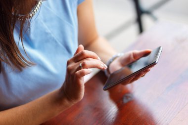 Genç bir kadın akıllı telefonunu kullanıyor