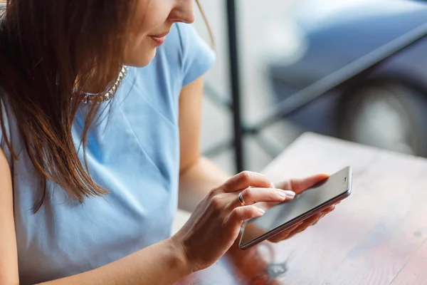 Una joven está usando su teléfono inteligente — Foto de Stock