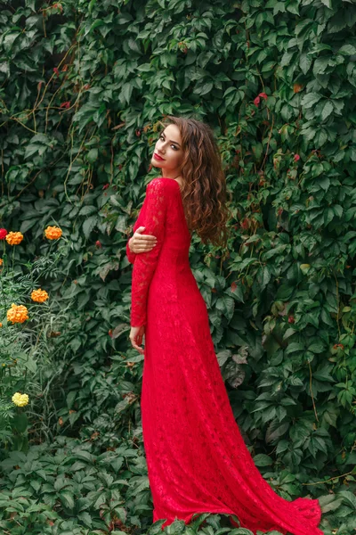 Beautiful young woman in long red dress — Stock Photo, Image