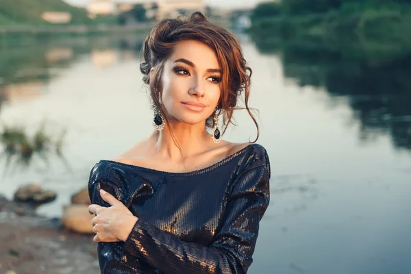 Mooie jonge modieuze vrouw poseren in jurk op de kust van de rivier — Stockfoto