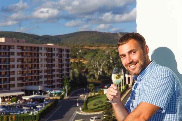 Hezký chlap stojí na balkóně — Stock fotografie