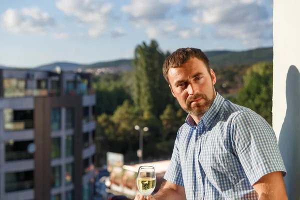 Schöner Kerl steht auf dem Balkon — Stockfoto