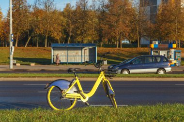 Sokakta park yeri kiralamak için modern sarı bisiklet. Güneşli sonbahar sabahı.