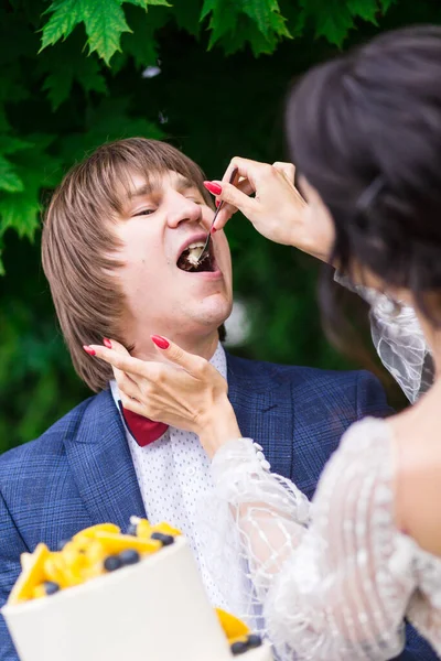 新婚旅行や新婦付添人は結婚式の宴会で新鮮な空気の中で一緒に楽しいし 結婚式のケーキを食べる — ストック写真