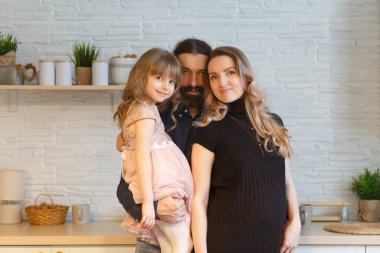 Mutfaktaki aile. Kocasına ve küçük kızına hamile bir kadın..