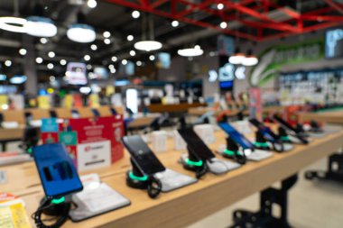 Modern elektronik mağazasında akıllı telefonların olduğu bir vitrin. Bir cep telefonu al. Teknoloji mağazasının rafında birçok akıllı telefon var. Arkaplan olarak bulanık resim.