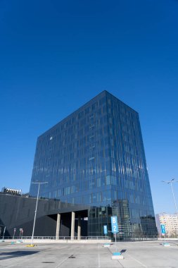 Bulutlu gökyüzü ve güneşin birden fazla yansıması olan ön cephenin mimari ayrıntıları. Modern binanın dış cephesi. Mimari soyut arkaplan