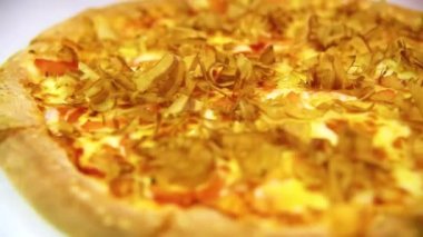 Somon talaşı serpiştirilmiş sıcak deniz ürünleri pizzası. Talaşlar sanki canlıymış gibi sıcak pizzanın üzerinde hareket ediyor.