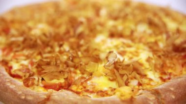 Somon talaşı serpiştirilmiş sıcak deniz ürünleri pizzası. Talaşlar sanki canlıymış gibi sıcak pizzanın üzerinde hareket ediyor.  