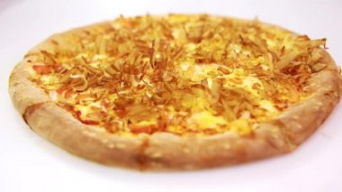 Somon talaşı serpiştirilmiş sıcak deniz ürünleri pizzası. Talaşlar sanki canlıymış gibi sıcak pizzanın üzerinde hareket ediyor.  
