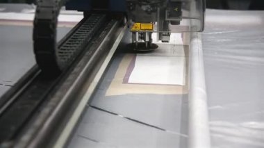 Endüstriyel giysi fabrikasında özel bir lazer kesici kumaş bazı tekstil parçalarını kesiyor. Lazer makinesi kavramı, fabrikada çalışmak, otomatik kesim.
