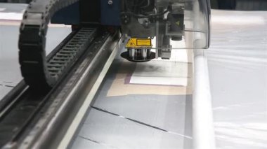 Endüstriyel giysi fabrikasında özel bir lazer kesici kumaş bazı tekstil parçalarını kesiyor. Lazer makinesi kavramı, fabrikada çalışmak, otomatik kesim.
