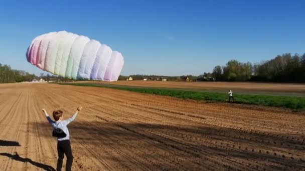 两个男孩在犁地里向天空发射了一个明亮的彩虹风筝 在田里与风玩耍 夏天的概念 课间休息生活方式 4K镜头 — 图库视频影像