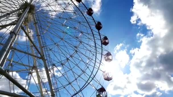 Lapso de tempo de uma roda gigante com sol brilhante e nuvens em movimento no fundo — Vídeo de Stock