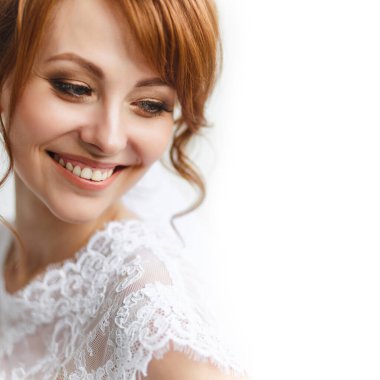 Gelinin yakın plan portresi mutlu, gülümseyen bir yüzü, güzel gözleri, hafif bir arkaplanda düğün gününde bir kadının nazik fotoğrafı, mesaj için yer, gülücük ve eğlenceli.