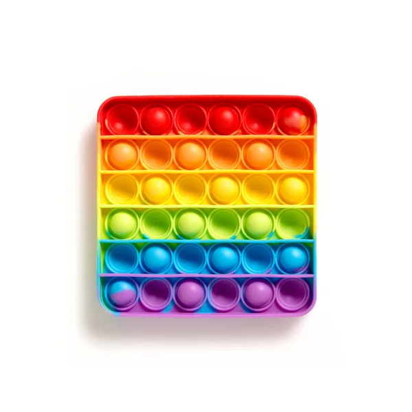 アンチストレス虹は それが白い背景にフィジェットポップ 子供のためのシンプルなディンプル感覚ゲーム 手や指のためのモータスキルの開発 白い空のコピースペースに隔離されたポピットシリコーン — ストック写真