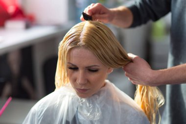 Grodno, Belarus - 20 Ekim 2016: Keune marka teknoloji uzmanı Artem Raychuk, Kolibri güzellik salonuna katılımıyla reklam atölyesindeki bir modelin saçını boyadı.