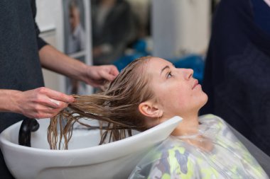 Grodno, Belarus - 20 Ekim 2016: Keune marka teknoloji uzmanı Artem Raychuk, Kolibri güzellik salonuna katılımıyla reklam atölyesindeki bir modelin saçını boyadı.