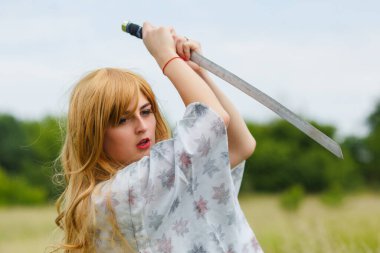 Geleneksel kimonolu genç Asyalı kadın dışarıda katana kılıcıyla dövüş teknikleri öğretiyor, samuray savaşçısı kız.