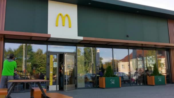 Клієнт виходить з ресторану McDonalds з покупками. — стокове відео