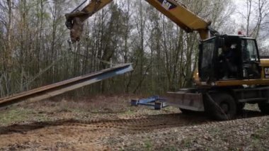 Siper duvarlarının korumak için metal destekler montajı.