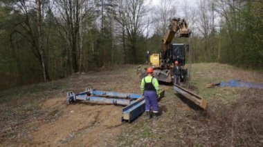 Siper duvarlarının korumak için metal destekler montajı.
