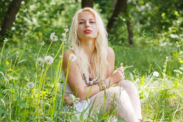 Çimlerde oturan sarışın kız — Stok fotoğraf