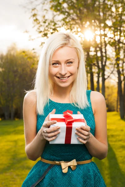 Beautiful blond girl holding box with a gift — Stock Photo, Image