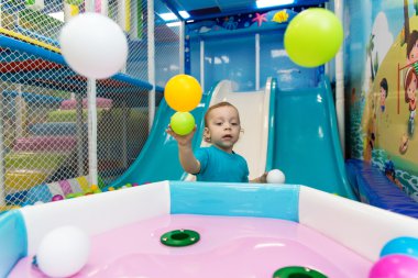 küçük çocuk toplarla oynuyor