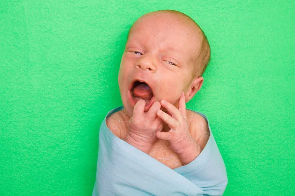 Bebê recém-nascido que coloca na capa verde — Fotografia de Stock