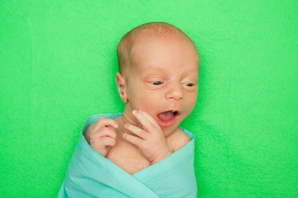 Bebê recém-nascido que coloca na capa verde — Fotografia de Stock